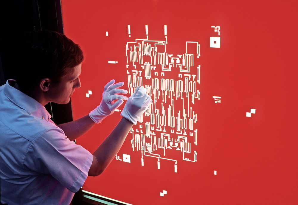 A technician makes a correction to a Rubylith mask. Image credit: US National Archives